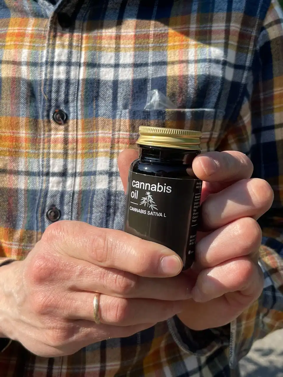 Bărbat ținând borcanul Cannabis Oil